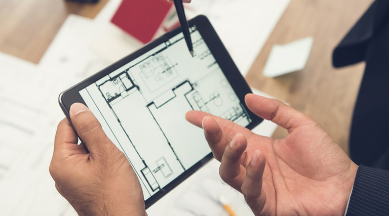 Leaders plan using a blueprint on a tablet
