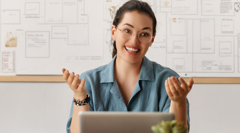 Woman speaking from behind a laptop